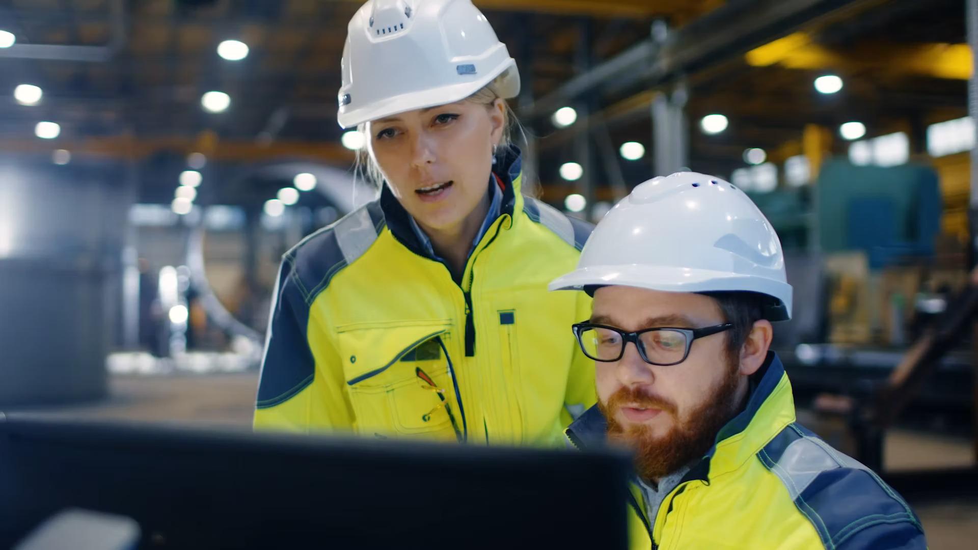 two factory workers looking at screen