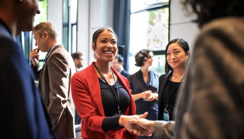 A businesswoman shaking the hands of her partners at a major conference