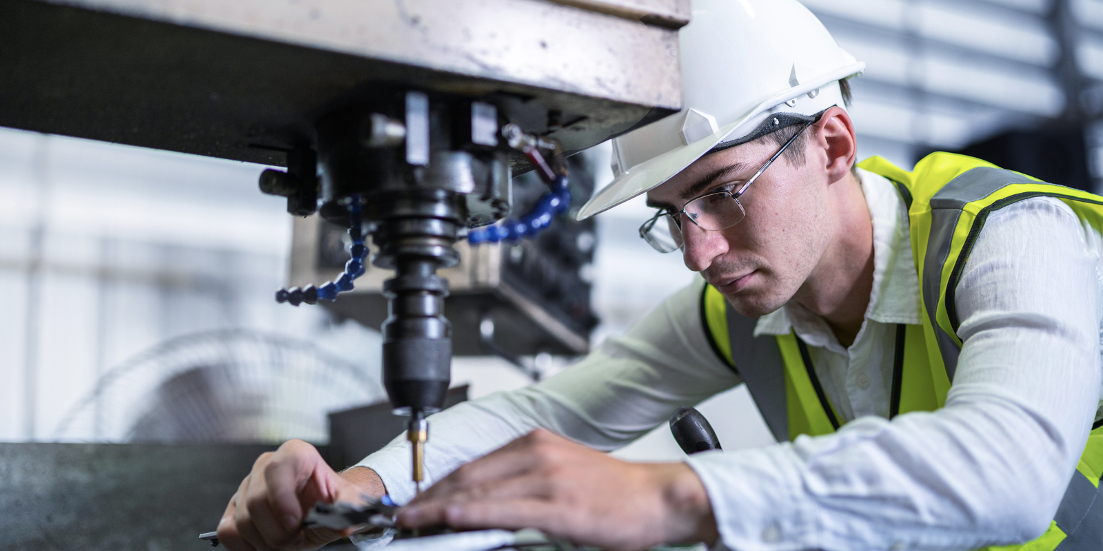 Male engineer working with machine at manufacturing factory