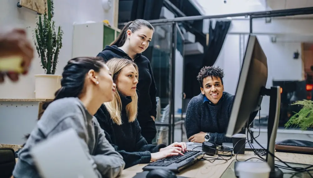 Des collègues discutant d’agents IA devant un ordinateur portable
