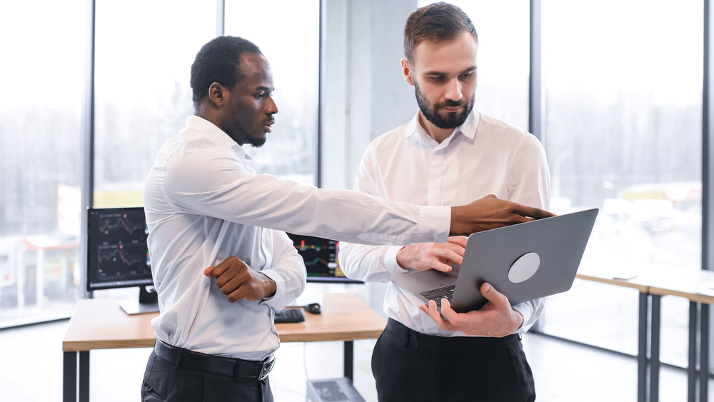 Managers using supply chain planning software on a laptop