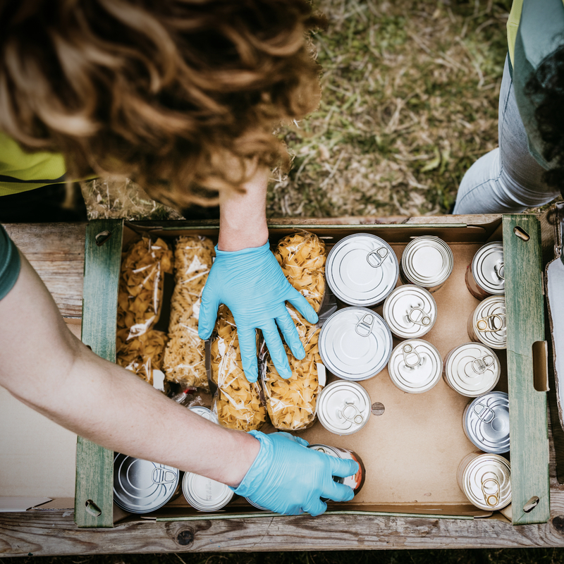 Male and female friends arranging food in cardboard boxes