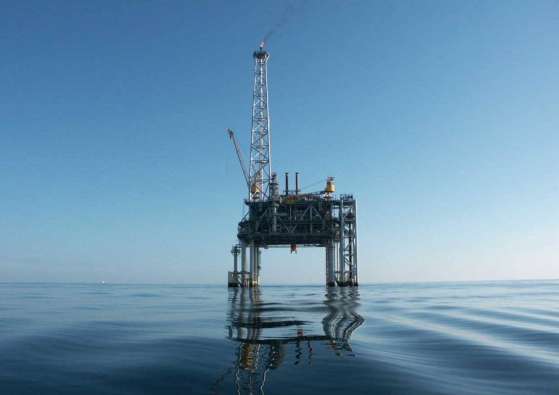 photo from ground level of an oil rig in the ocean