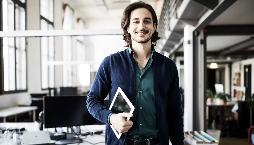 Smiling businessman holding a tablet