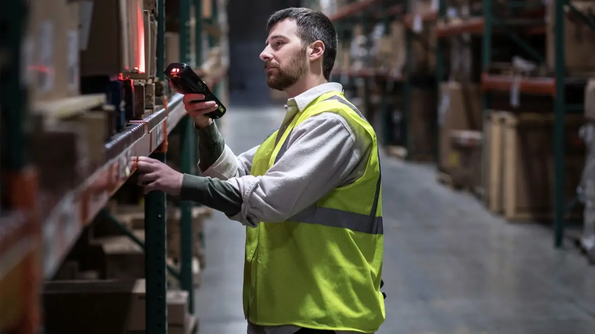 Worker scanning boxes in a distribution warehouse