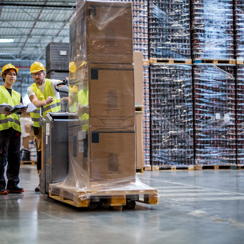 Employees consult while working in warehouse. Global Transportation