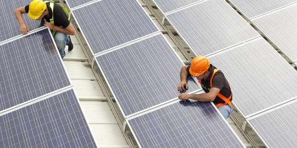 utilities technicians installing solar panels