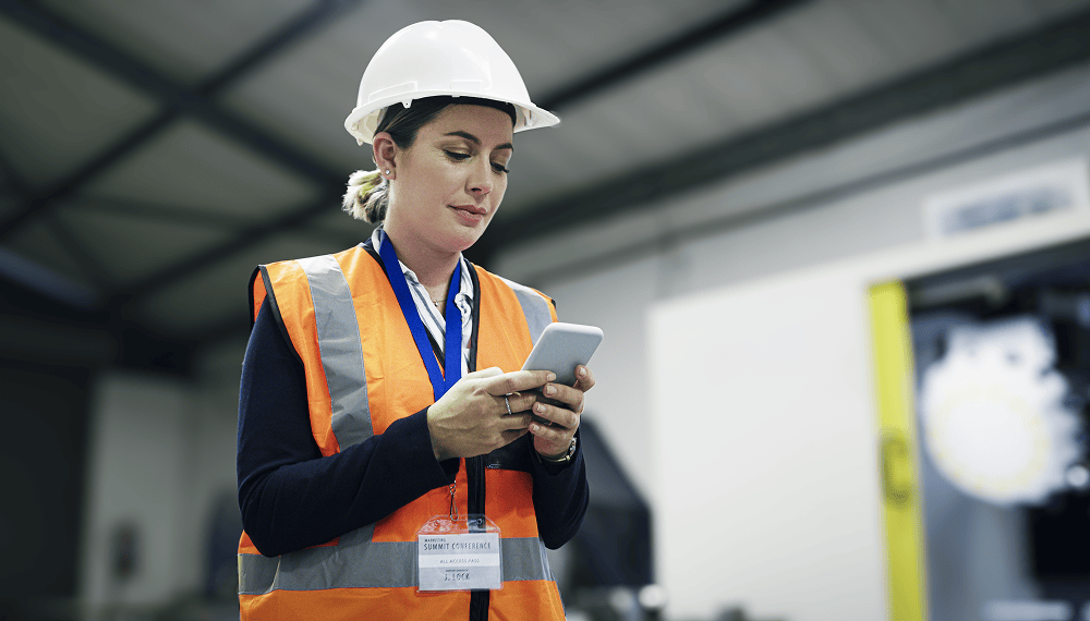 A utilities worker looking at a smartphone