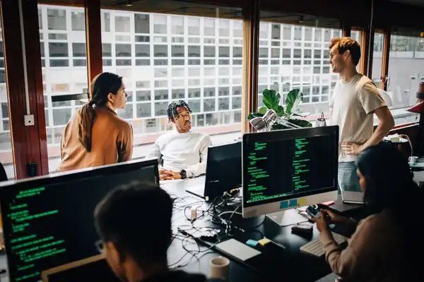 Team gathered around a desk in an office 