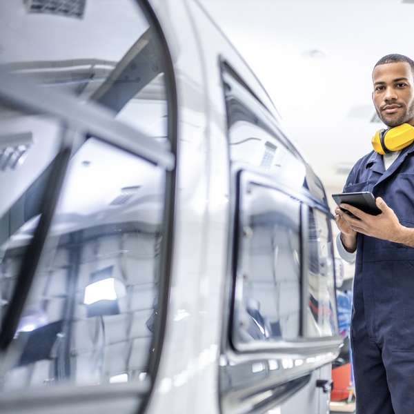 Helicopter engineer holding a mobile device adjacent to a helicopter 