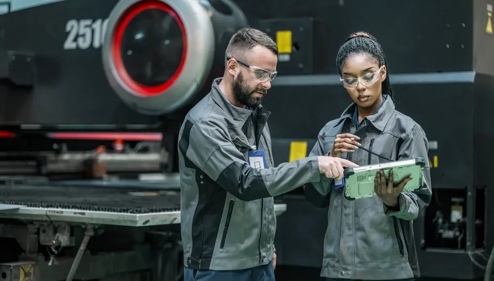 Engineers reviewing POs on a tablet