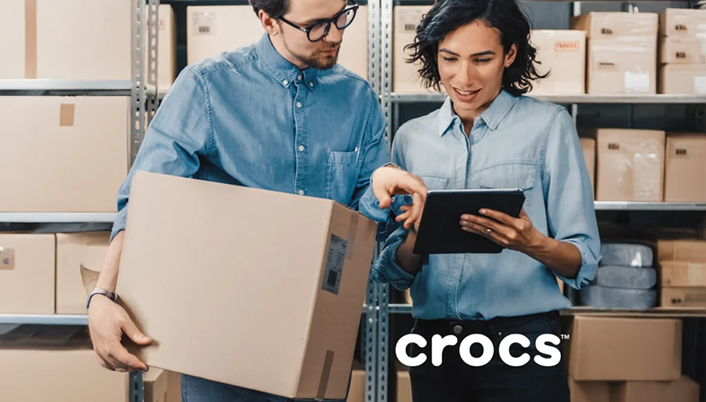 Crocs warehouse employees looking at a tablet
