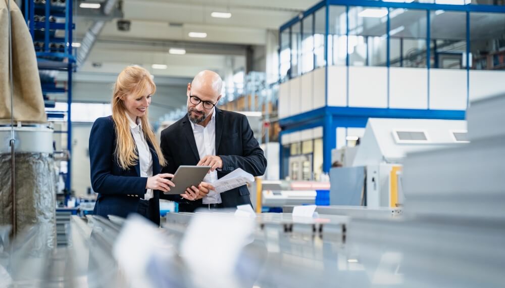 Managers using ERP on a tablet in a factory