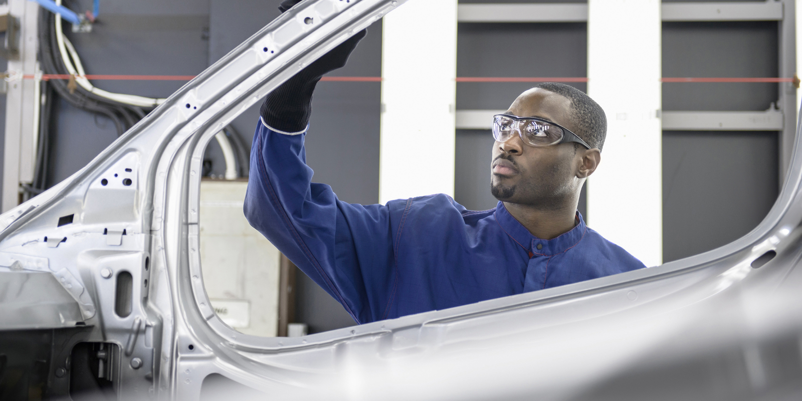 Worker inspecting car factory