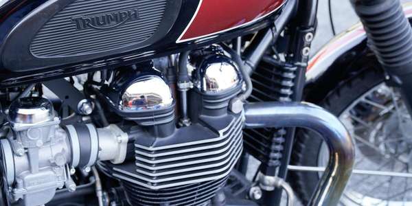 369891302_triumph-vintage-logo-sign-and-text-on-motorcycle-detail-on-red-fuel-tank_AdobeStock
